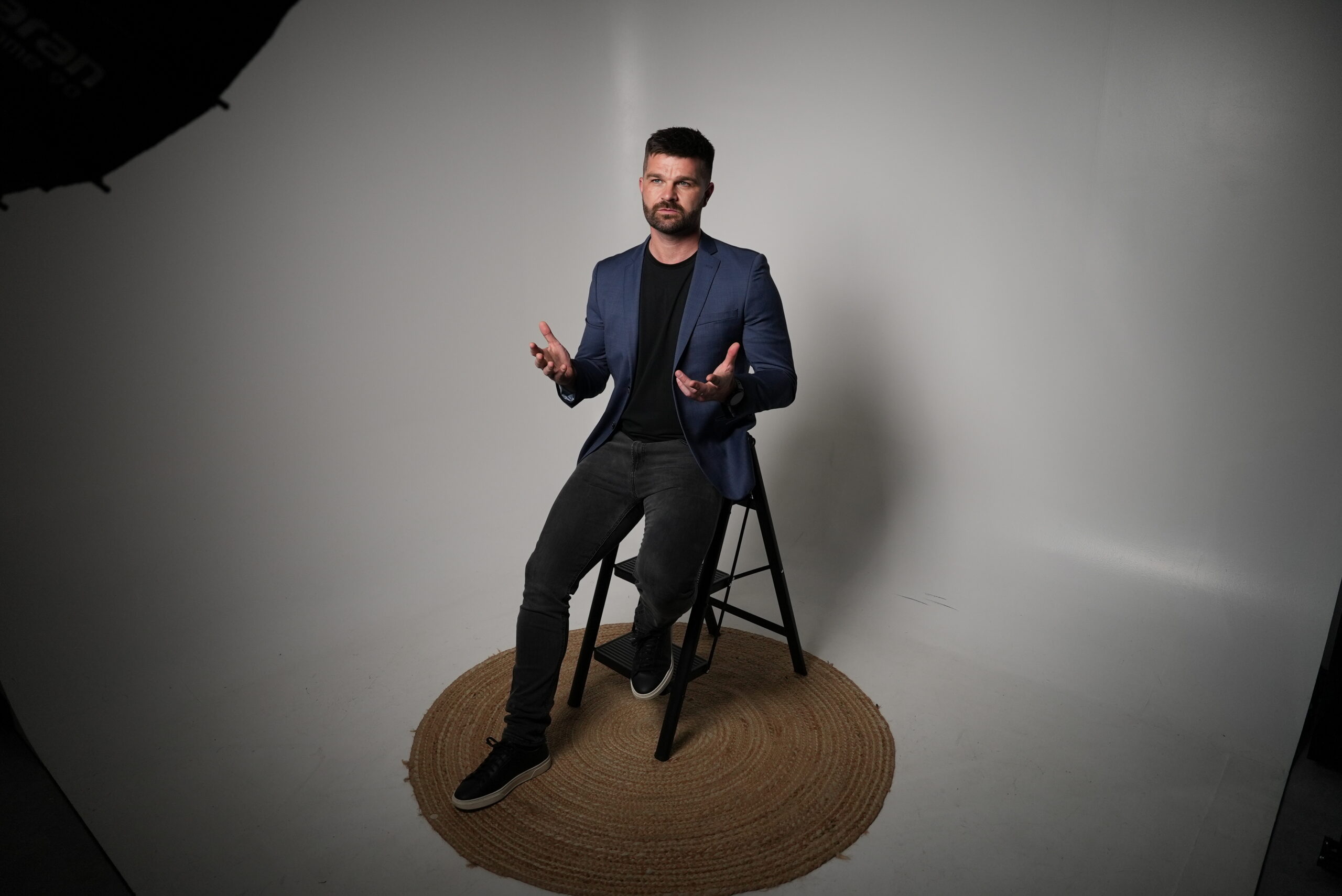 Joe Sharp seated on a stool, talking